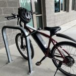 An electronic bike secured to a bike rack with a U lock.